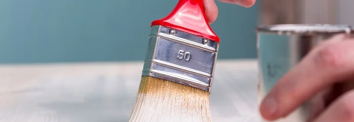 Person streicht Holz weiß